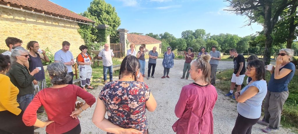 Groupe de personnes discutant en extérieur.