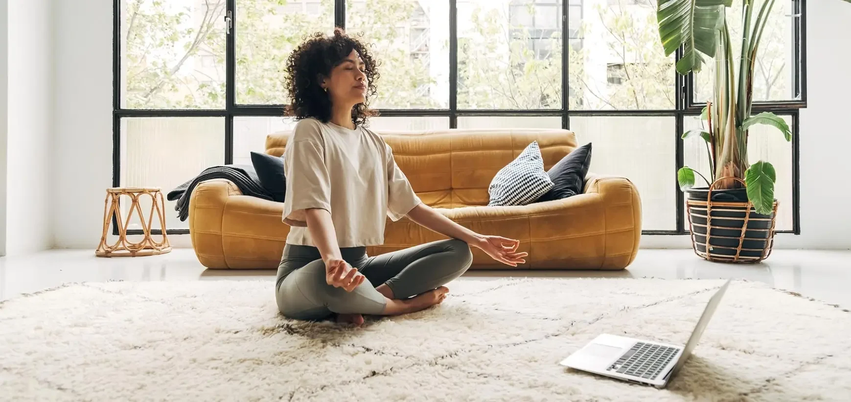 Personne méditant devant un ordinateur portable.