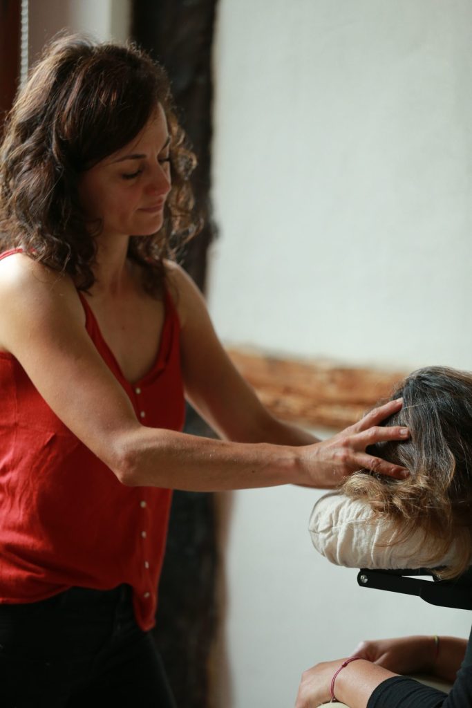 Massage crânien relaxant par une femme souriante.