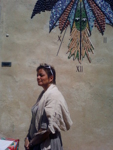 Femme devant horloge murale ensoleillée.