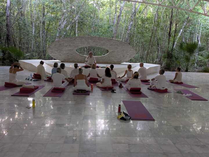Cours de yoga en groupe dans une salle lumineuse.